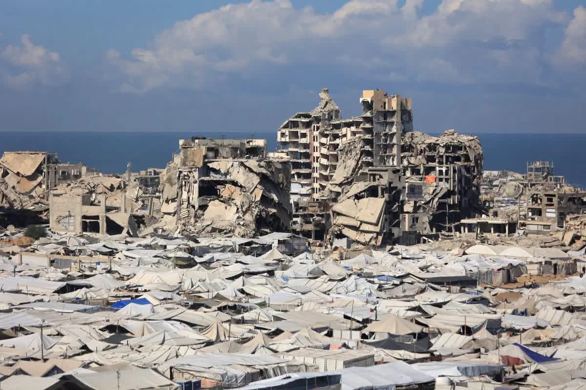 Palestinians walk through a damaged area of Gaza following Israeli strikes as the third anniversary of the October 7, 2023 Hamas attack is marked.
